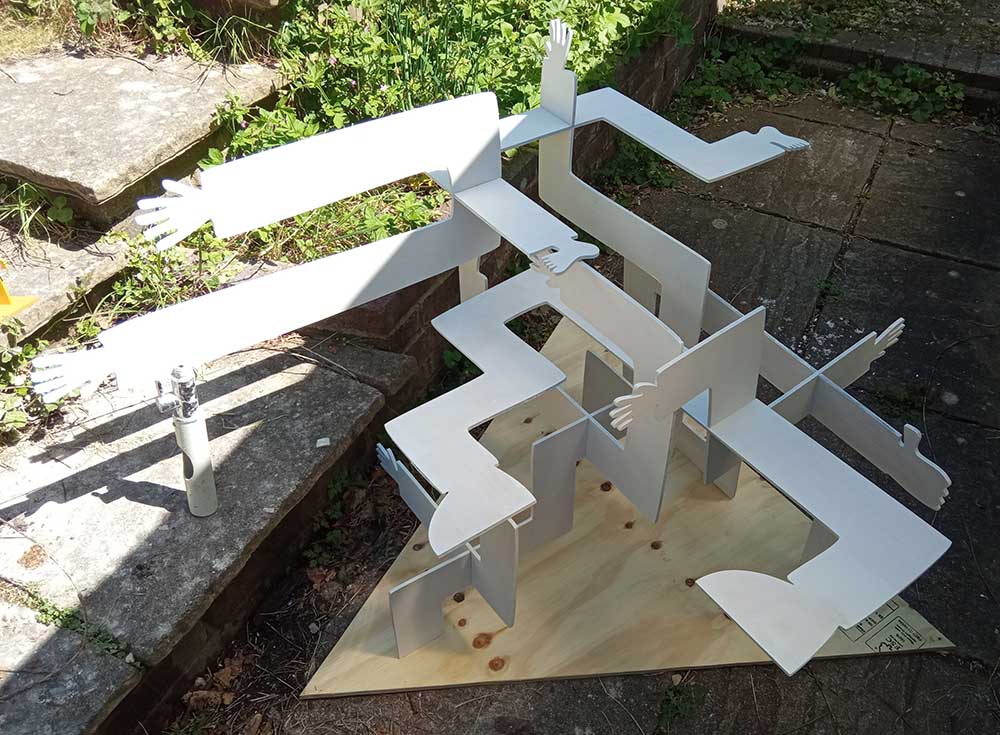 The larger sculpture is assembled in a garden background. All the pieces are primed besides the base, and one piece requires a supporting rod.